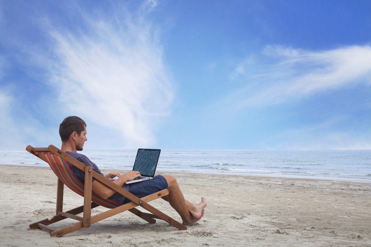 Человек с ноутбуком на пляже